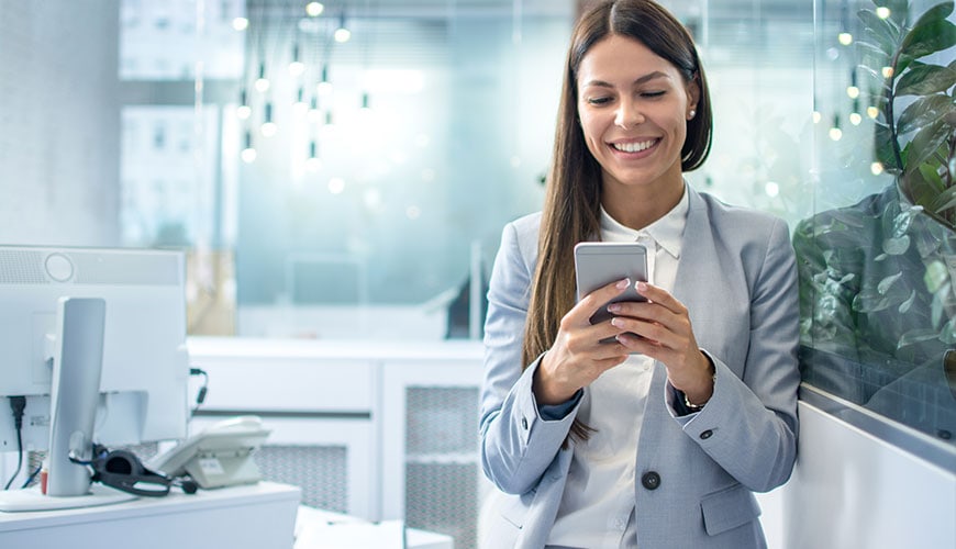 Illustration of employees using a desk booking app in a modern office environment, highlighting flexible workspace management and a smooth return-to-office experience.